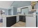A modern kitchen features black and white cabinets, stainless steel appliances, and an island countertop at 3700 Golf Colony Lane # 13-H, Little River, SC 29566
