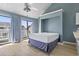 Comfortable main bedroom features light-filled balcony, sleek ceiling fan, and soft blue walls at 3700 Golf Colony Lane # 13-H, Little River, SC 29566