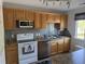 Well-lit kitchen features oak cabinets, stainless steel appliances, and tile backsplash at 380-K Myrtle Greens Dr. # 380-K, Conway, SC 29526