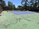 Outdoor tennis court with a blue and green painted surface, net, and surrounding green trees near the residences at 380-K Myrtle Greens Dr. # 380-K, Conway, SC 29526
