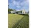 View of a lush backyard with a well-manicured lawn and a home with a metal roof at 382 Waties Dr., Murrells Inlet, SC 29576