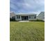 Exterior view of a home with a metal roof, covered patio, and expansive green lawn at 382 Waties Dr., Murrells Inlet, SC 29576