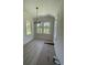 Bright dining area with light wood floors, white trim, modern chandelier, and abundant natural light from multiple windows at 382 Waties Dr., Murrells Inlet, SC 29576