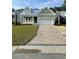 Charming one-story home with a two-car garage, manicured lawn, and brick paver driveway at 382 Waties Dr., Murrells Inlet, SC 29576