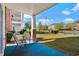 Screened porch overlooking green space with pond, trees, and other buildings at 3927 Gladiola Ct. # 101, Myrtle Beach, SC 29588