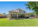 View of the rear exterior with brick and siding, large backyard, and covered patio at 404 Club Dr., Myrtle Beach, SC 29572