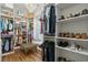 A spacious walk-in closet featuring custom shelving, a chandelier, and a window seat at 404 Club Dr., Myrtle Beach, SC 29572