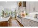 Bright kitchen with white cabinets, marble countertops, a large island, and modern stainless steel appliances at 404 Club Dr., Myrtle Beach, SC 29572