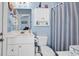 Cozy bathroom with blue accents, a vanity sink, and a shower with striped curtain at 4350 Grande Harbour Blvd., Little River, SC 29566