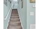 Carpeted staircase with a white handrail and light blue walls adorned with decorative wall art at 4350 Grande Harbour Blvd., Little River, SC 29566