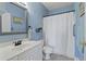 Well-lit bathroom with a white vanity, shower with curtain, and modern fixtures at 4503 W Harbour Ct. # S-12, Little River, SC 29566