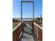 Picturesque beach access with a wooden walkway leading to a gate and the sandy shore at 4800 S Ocean Blvd. # 1418, North Myrtle Beach, SC 29582
