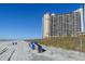 Oceanfront view of high-rise condo building from sandy beach with blue skies at 4800 S Ocean Blvd. # 1418, North Myrtle Beach, SC 29582