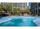 Large pool with clear blue water, surrounded by lounge chairs and palm trees at 4800 S Ocean Blvd. # 1418, North Myrtle Beach, SC 29582
