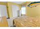 A sunny bedroom with yellow walls, fish art, a window, and a double door closet at 4814 Innisbrook Ct. # 412, Myrtle Beach, SC 29579