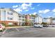 A condo exterior with a brick base, white siding, balconies, and parking spots at 4814 Innisbrook Ct. # 412, Myrtle Beach, SC 29579