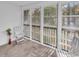 Enclosed sunroom with a nice view of the trees, features white walls and three white chairs at 4814 Innisbrook Ct. # 412, Myrtle Beach, SC 29579