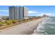 Breathtaking aerial view showcasing a high-rise condo, sandy beach, and rolling ocean waves at 504 N Ocean Blvd. # 401, Myrtle Beach, SC 29577