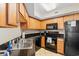 Well-equipped kitchen featuring wooden cabinetry, black appliances, and dark granite countertops at 504 N Ocean Blvd. # 401, Myrtle Beach, SC 29577