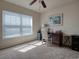 Bright bedroom with neutral carpet features a ceiling fan and natural light from the window at 511 Mattamushkeet Dr., Little River, SC 29566