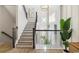 Elegant staircase with wooden railings, a stylish chandelier, and natural light streaming through the windows at 512 9Th Ave. S, North Myrtle Beach, SC 29582