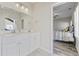 Bathroom featuring double vanity, white cabinetry and view into bedroom at 514 Vallecrosia Ct., Little River, SC 29566