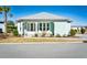 Charming beach house with a covered porch, white Adirondack chairs, and a vibrant turquoise exterior at 5223 Sea Coral Way, North Myrtle Beach, SC 29582