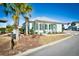 Inviting beach house with light blue exterior, white trim, and cozy porch seating beneath palm trees at 5223 Sea Coral Way, North Myrtle Beach, SC 29582