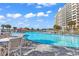 Large community pool with beach access featuring chairs, tables, and a nearby cabana, surrounded by palm trees at 5223 Sea Coral Way, North Myrtle Beach, SC 29582