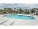 Community pool featuring lounge chairs, lush landscaping, and clear blue water for relaxation and recreation at 5223 Sea Coral Way, North Myrtle Beach, SC 29582