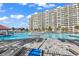 Resort-style pool surrounded by lounge chairs, palm trees, and an impressive condo building under a partly cloudy sky at 5223 Sea Coral Way, North Myrtle Beach, SC 29582