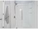 A bright, white, marble-like shower with a glass door, shelving, and a gray towel hanging nearby at 5628 Camilla Ct., Myrtle Beach, SC 29579