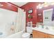 Bright bathroom with a tub and shower combination with red accent wall with a decorative shower curtain at 611 Indigo Bunting Ln. # 42 E, Murrells Inlet, SC 29576