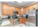 Well-equipped kitchen with stainless steel appliances, wooden cabinets, and tile flooring at 611 Indigo Bunting Ln. # 42 E, Murrells Inlet, SC 29576