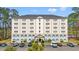 Six story building with neutral colors, black roof, and parking lot, surrounded by trees at 6850 Blue Heron Blvd. # 205, Myrtle Beach, SC 29588
