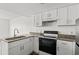 Kitchen featuring white cabinets, granite countertops, and black appliances at 6850 Blue Heron Blvd. # 205, Myrtle Beach, SC 29588