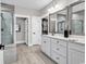 Modern bathroom with dual vanities, large mirrors, and a glass-enclosed shower with a closet at 7205 Spoleto Dr., Myrtle Beach, SC 29572