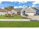 Charming single-story home featuring a well-manicured lawn, landscaped flower beds, and a two-car garage at 7205 Spoleto Dr., Myrtle Beach, SC 29572