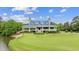 Stunning clubhouse overlooking the golf course, featuring a blue metal roof, veranda, and beautifully landscaped surroundings at 765 Pinehurst Ln. # 96-C, Pawleys Island, SC 29585