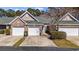 Charming townhome featuring a two-car garage, manicured landscaping, and a welcoming facade with brick and siding accents at 765 Pinehurst Ln. # 96-C, Pawleys Island, SC 29585
