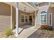 Inviting front porch featuring classic columns, decorative lighting, and colorful planters, creating a warm entry at 765 Pinehurst Ln. # 96-C, Pawleys Island, SC 29585