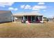 Exterior view of backyard featuring a screened in porch, patio seating and a hot tub at 900 Pelagic Loop, Myrtle Beach, SC 29579
