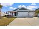 Charming home featuring a three car garage, manicured lawn, and inviting front porch adorned with flags at 900 Pelagic Loop, Myrtle Beach, SC 29579