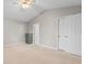A spacious main bedroom showcasing neutral carpeting, a ceiling fan, and access to a closet and ensuite bathroom at 1202 Formby Ct., Myrtle Beach, SC 29588