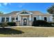 Exterior view of the community clubhouse with stone columns, manicured landscaping, and ample parking at 133 Hartwell Dr., Little River, SC 29566