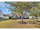 Traditional brick home with mature trees and landscaping. View of the front yard and white picket fence at 133 Hartwell Dr., Little River, SC 29566