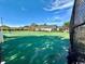 Outdoor community tennis court with a green surface and a black fence, in a well-maintained neighborhood at 133 Hartwell Dr., Little River, SC 29566