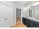 Bathroom with double sink vanity, walk-in closet, and wood-look floors at 19 Coventry Pl., Pawleys Island, SC 29585