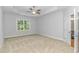 Spacious bedroom featuring tray ceilings, neutral carpet, large windows, and ensuite bathroom at 19 Coventry Pl., Pawleys Island, SC 29585