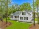 Beautiful white home featuring black shutters, complemented by a lush green lawn and mature trees at 19 Coventry Pl., Pawleys Island, SC 29585